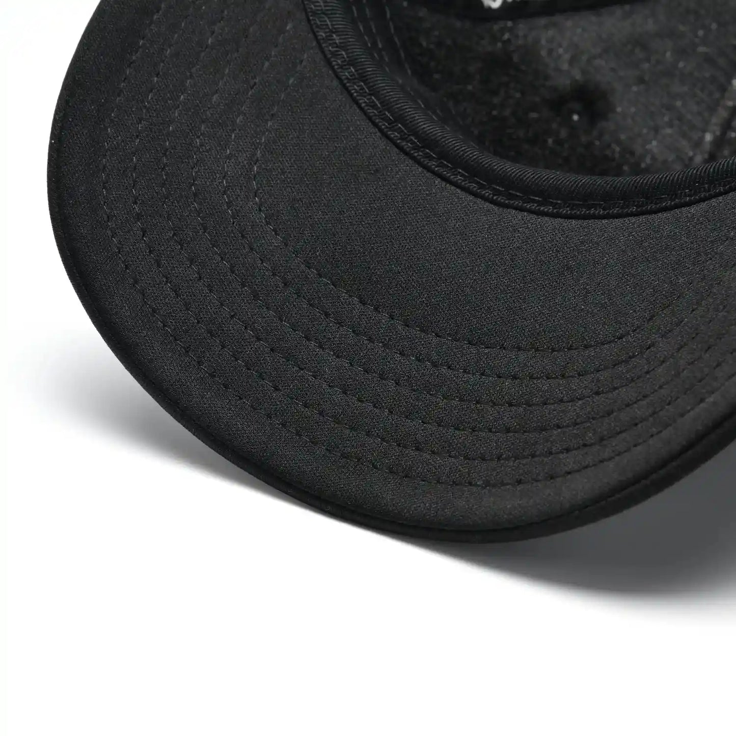 Close-up of Pagulayan black trucker cap curved bill with stitched detailing on the front brim.