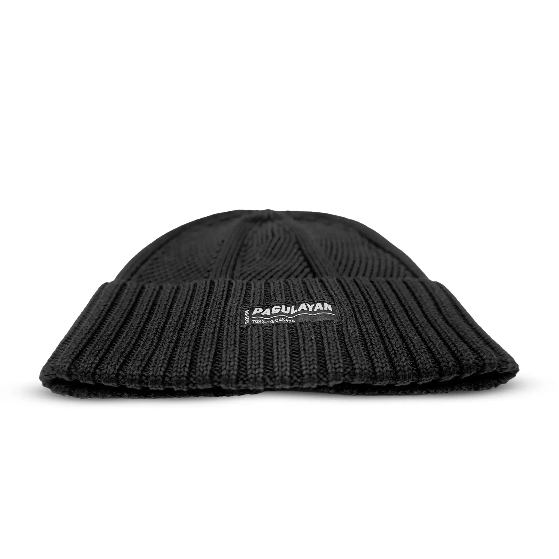 Low angle view of Pagulayan black cotton toque showing soft knit texture and Toronto Canada label on cotton beanie.