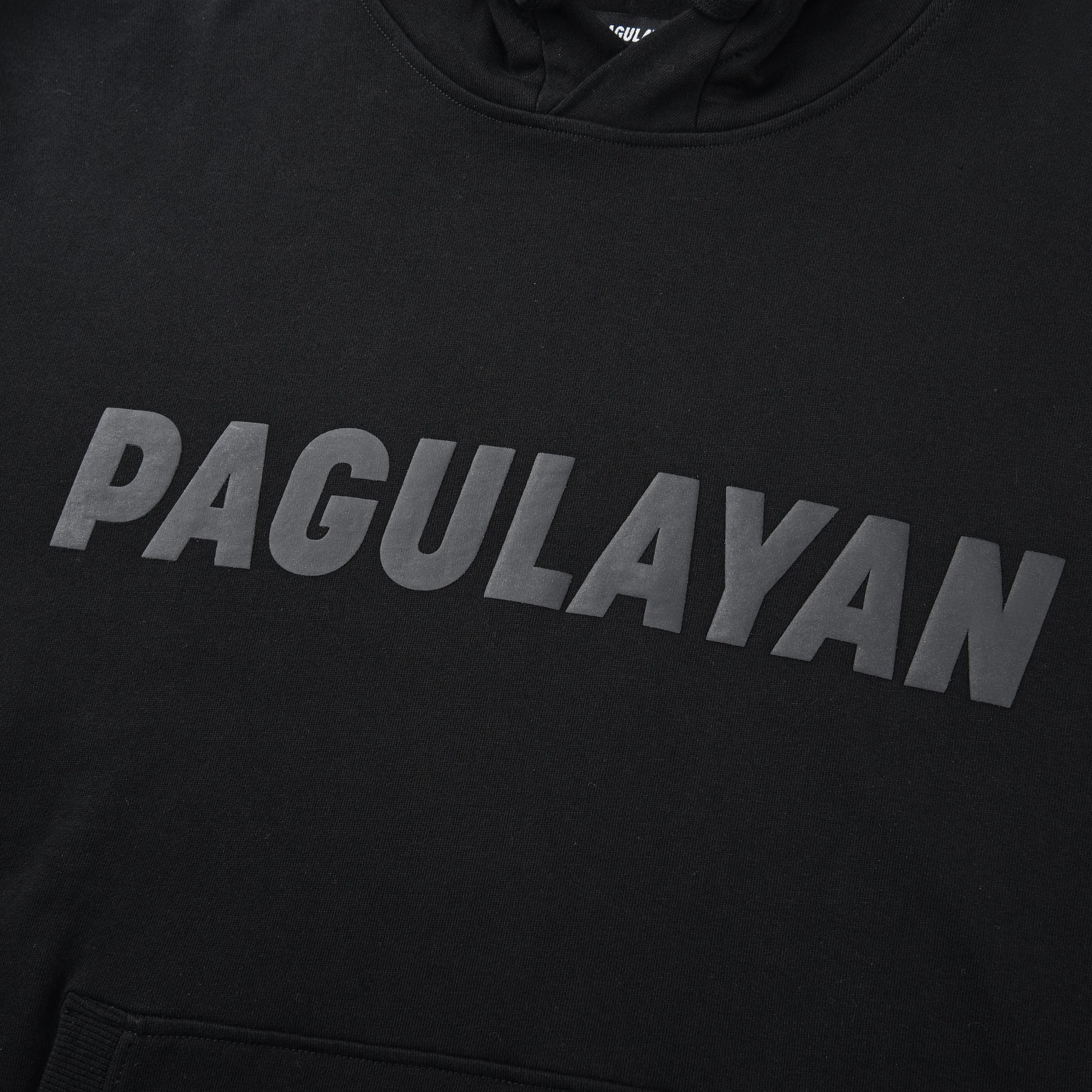 Close-up of the Blackout Hoodie chest showing the matte black Pagulayan logo across the front.