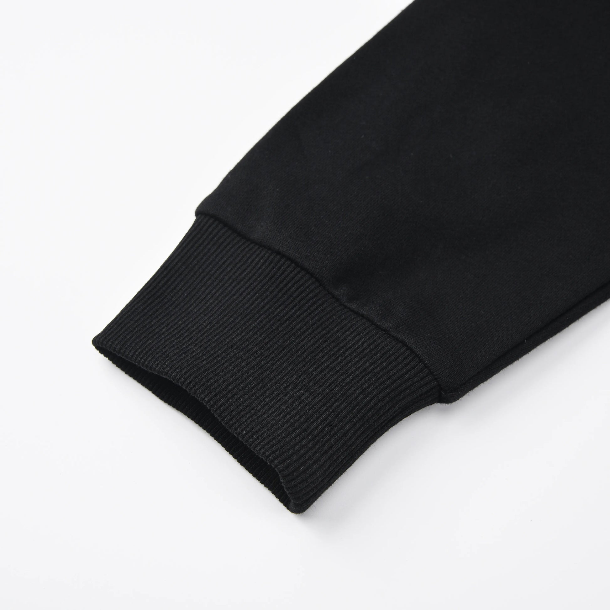 Close up of the Pagulayan Blackout Hoodie sleeve showing the ribbed cuff and smooth black fabric.