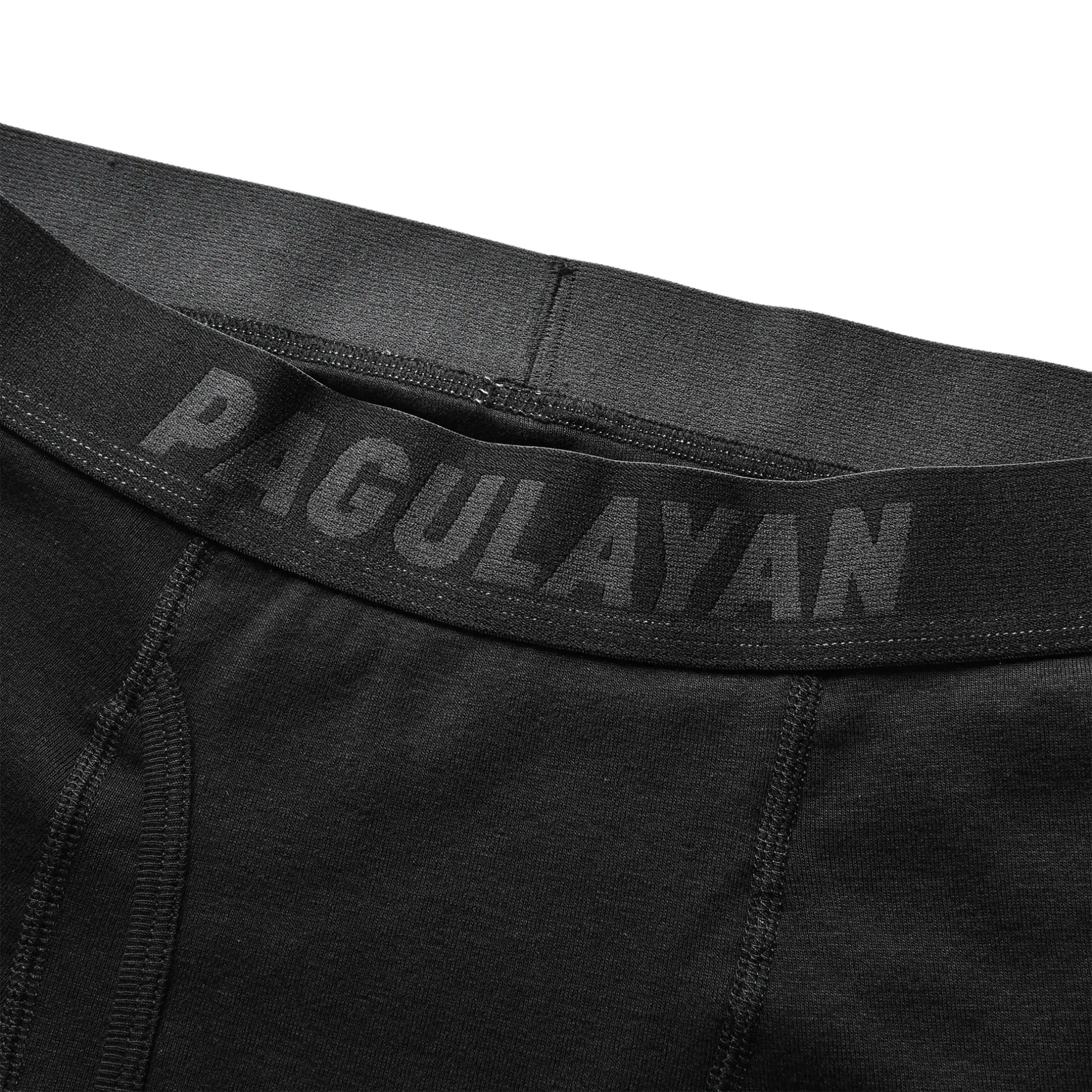 Close-up of black 100% cotton boxer briefs waistband with Pagulayan Cues branding and soft elastic fit.