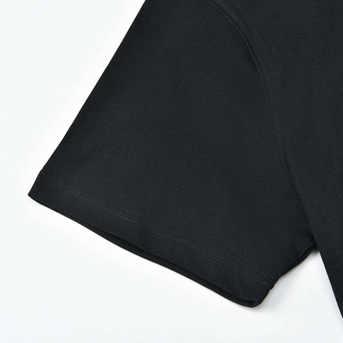 Close-up of the black Pagulayan PAGS Shirt sleeve with finished hem stitching.