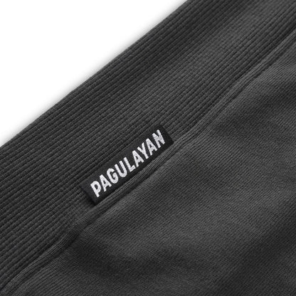 Close up of the Pagulayan Puff Logo Hoodie hem showing the woven brand label and ribbed fabric texture.