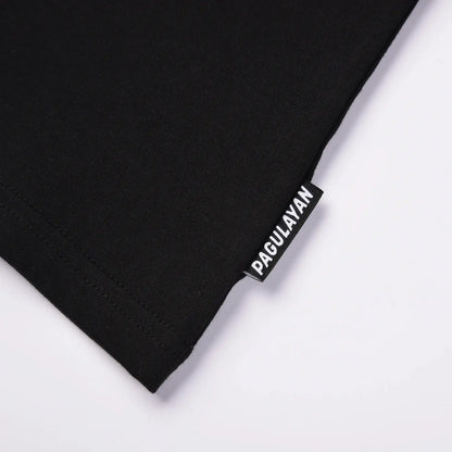Close up of Pagulayan brand tag on black cotton t shirt hem.