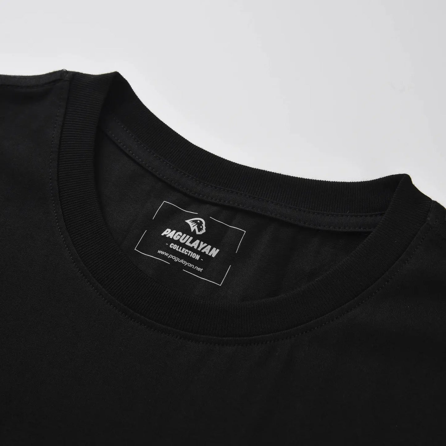 Ribbed crewneck collar and heat pressed Pagulayan label on The Subtle T-Shirt black cotton t shirt.