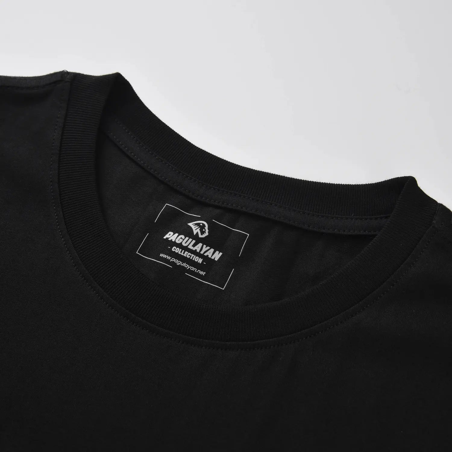 Ribbed crewneck collar and heat pressed Pagulayan label on The Subtle T-Shirt black cotton t shirt.