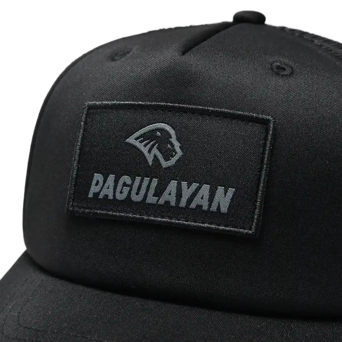 Pagulayan black 6 panel trucker cap with woven patch logo close-up on structured front panel.
