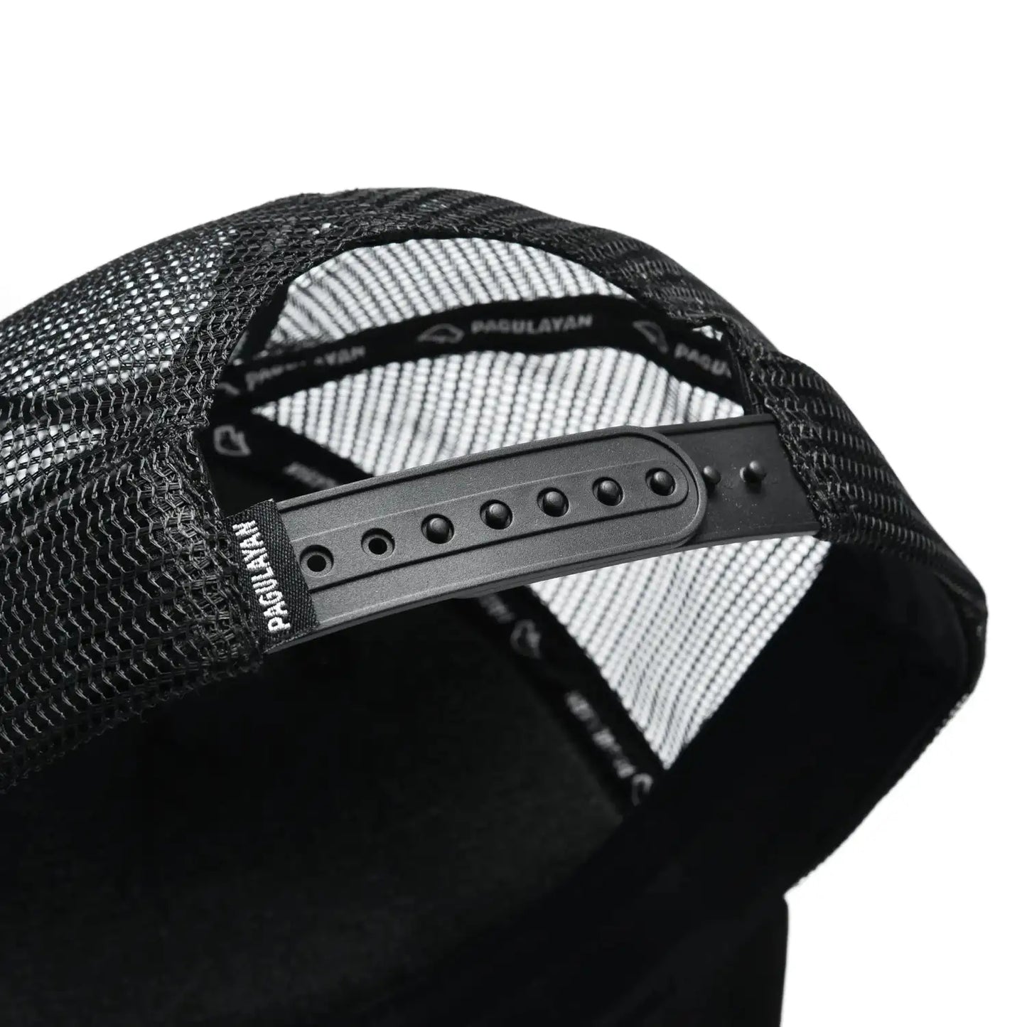 Close-up of Pagulayan black trucker cap adjustable snapback closure with breathable mesh back panels.