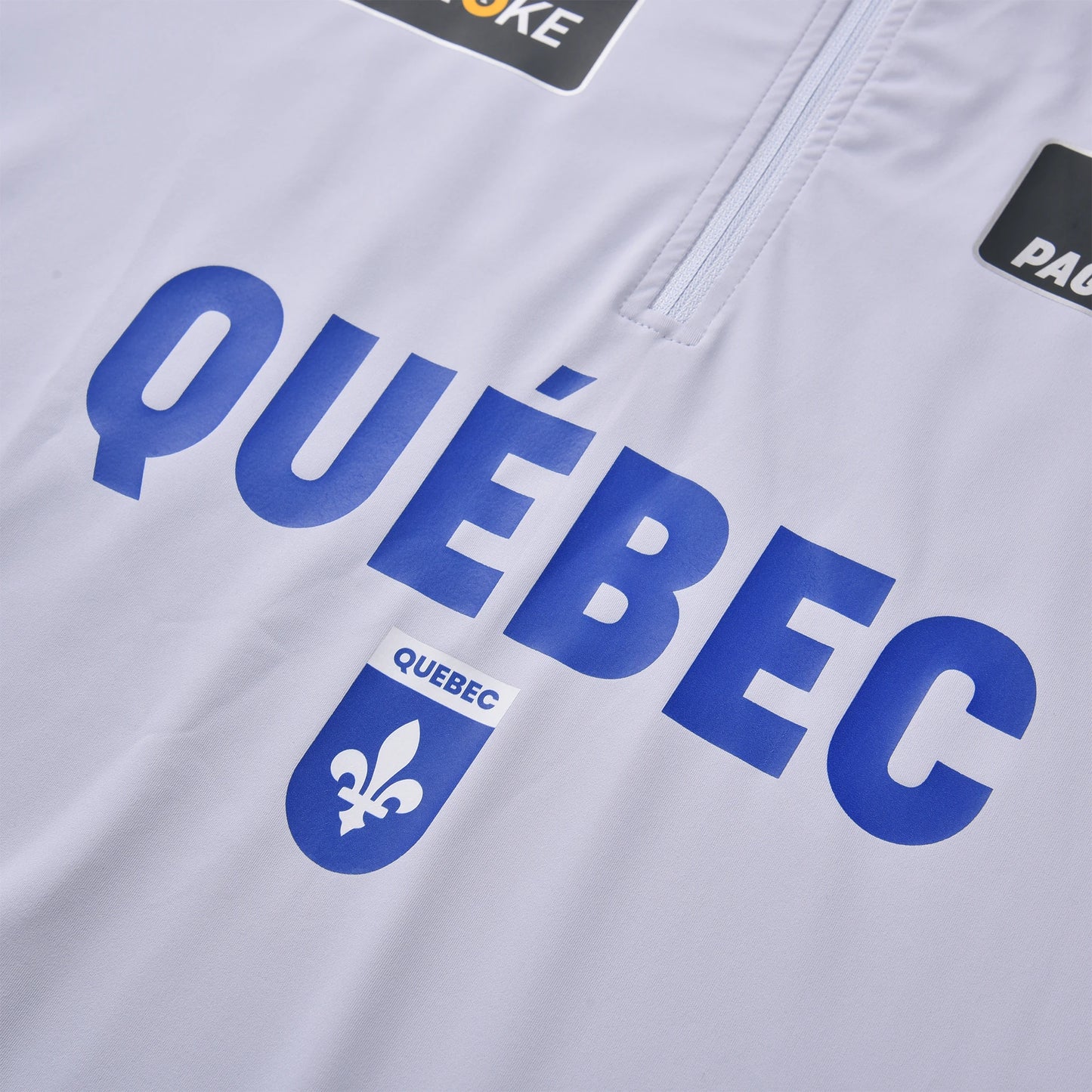 The close-up view of the Pagulayan Team Québec jersey shows the bold blue Québec text and fleur-de-lis emblem on white fabric.