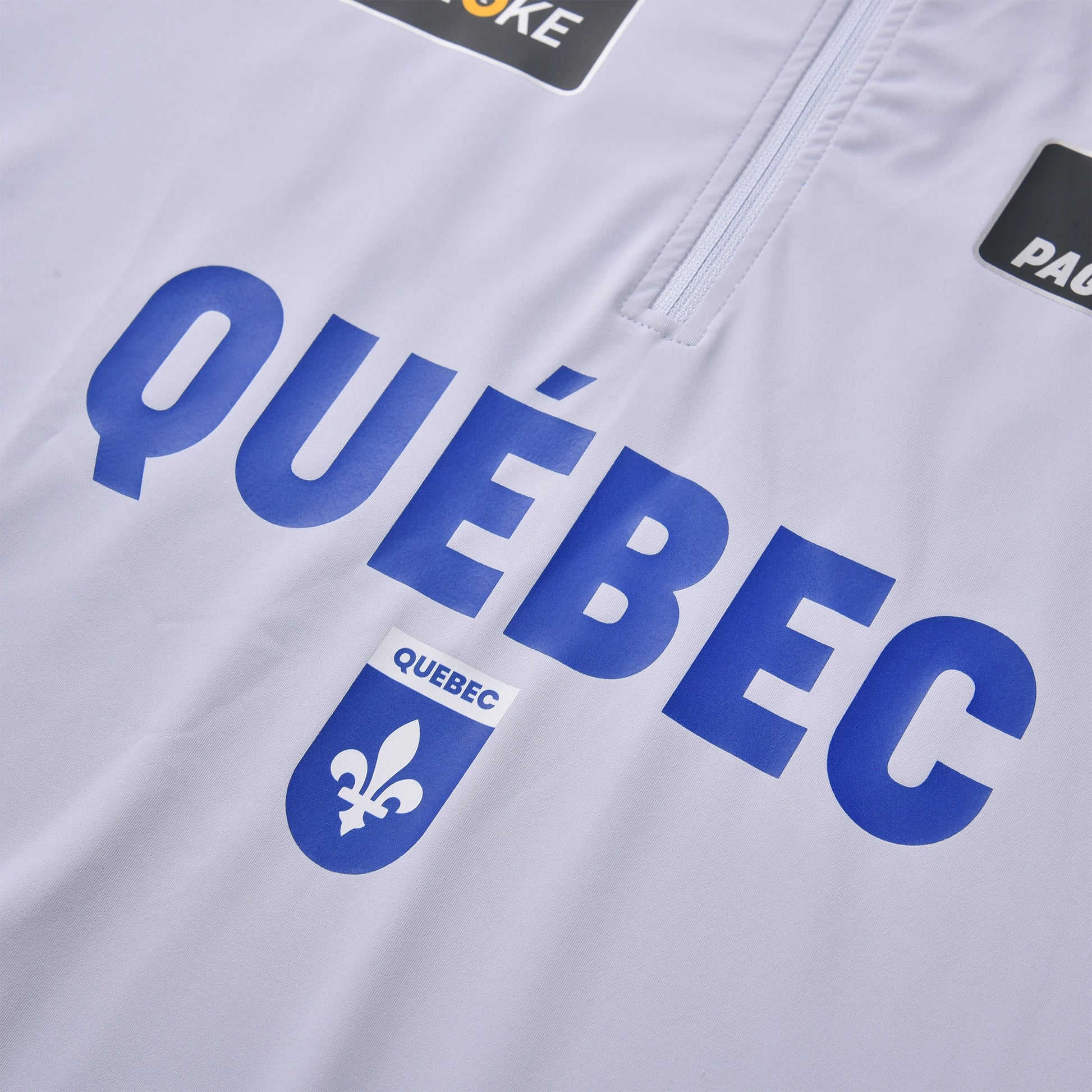 The close-up view of the Pagulayan Team Québec jersey shows the bold blue Québec text and fleur-de-lis emblem on white fabric.