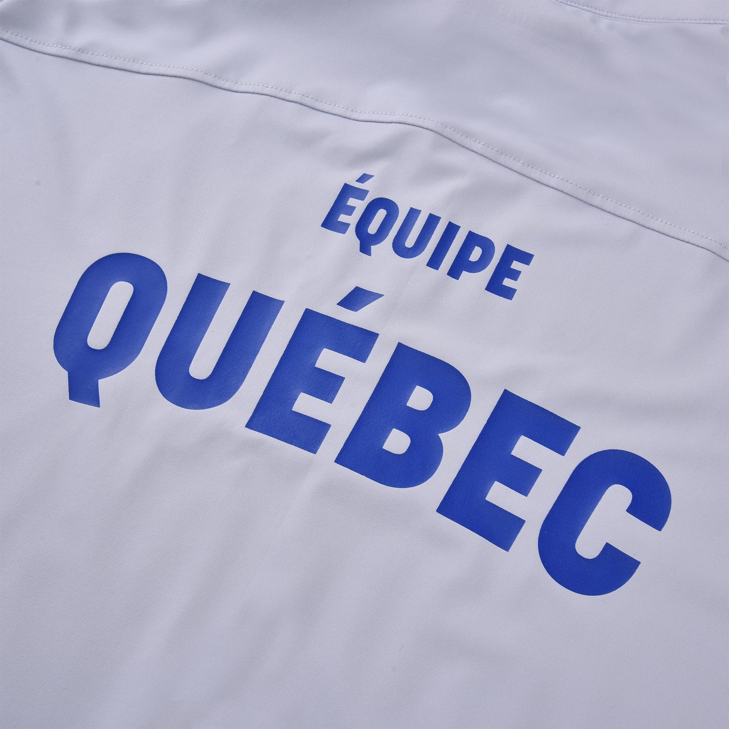 Close-up of the Pagulayan Team Québec jersey back showing the blue ÉQUIPE QUÉBEC text printed on white fabric.